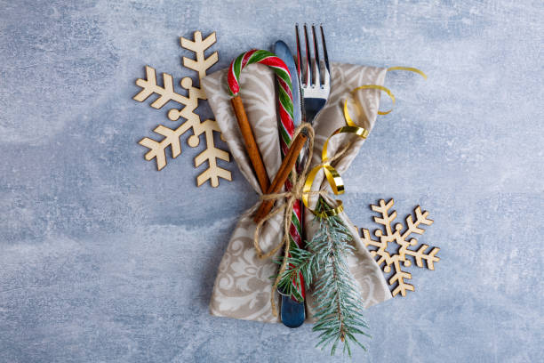 istock The knife and fork are wrapped, decorated with a ribbon, cinnamon , candy, beside decorative snowflakes. 883157446
