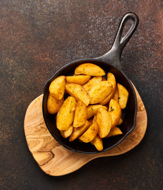 istock Roast potato on wooden board on brown background with copy space. Top view. 883157826