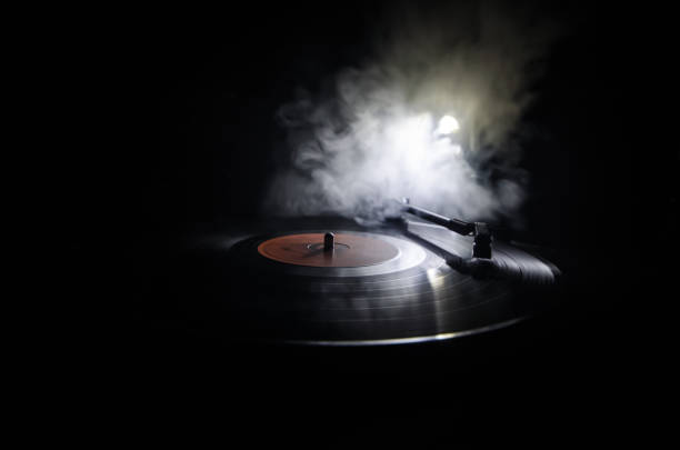 istock Turntable playing vinyl with glowing abstract lines concept on dark background. Selective focus 883160504
