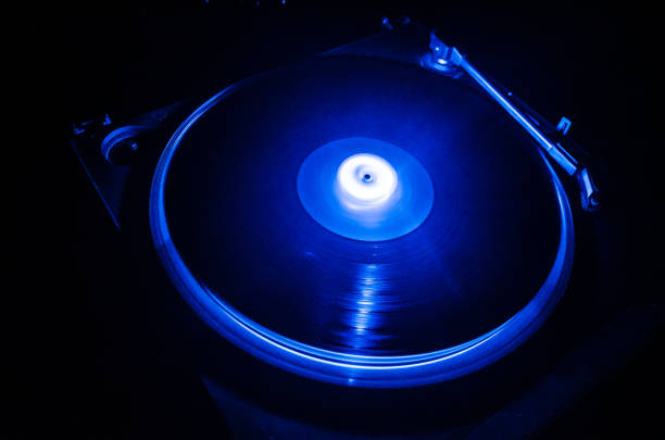 istock Turntable playing vinyl with glowing abstract lines concept on dark background. Selective focus 883160532