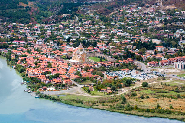Ancient town with red roofs, cathedral in the middle and blue water. stock photo