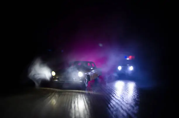 Police car chasing a car at night with fog background. 911 Emergency response police car speeding to scene of crime. Selective focus