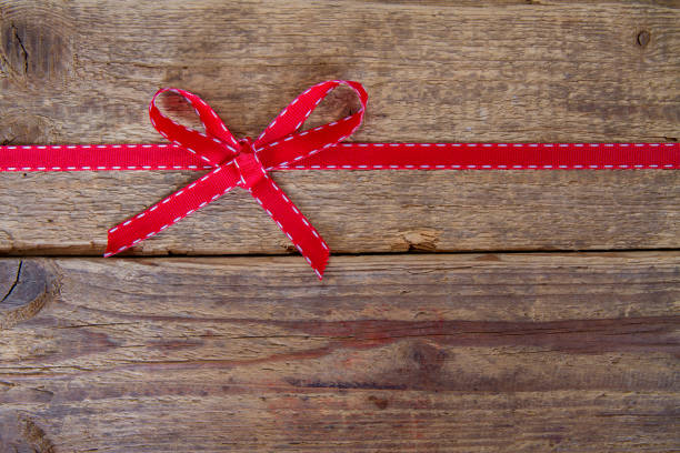 Red ribbon on wooden background stock photo