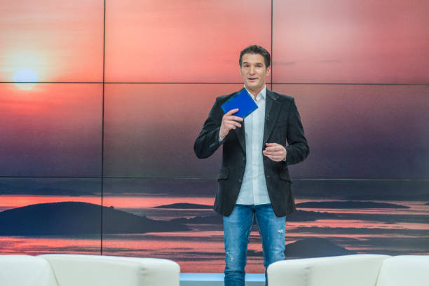 Talk show host Journalist standing in front of a digital display looking at camera, copy space. presenter stock pictures, royalty-free photos & images