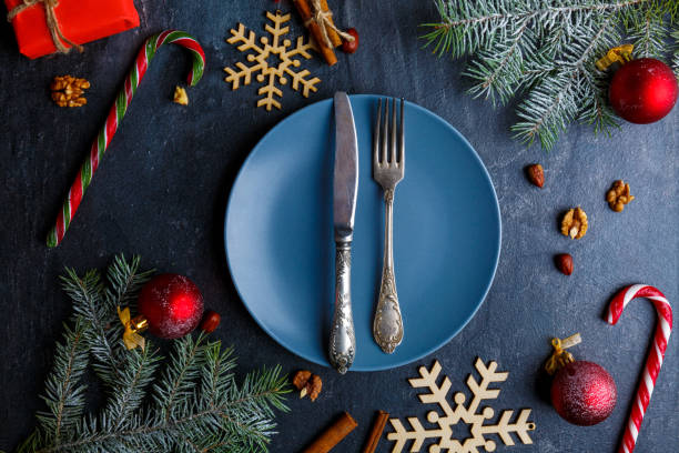 istock Around plate with a fork and knife there are many different Christmas decorations. View from above. 883161184