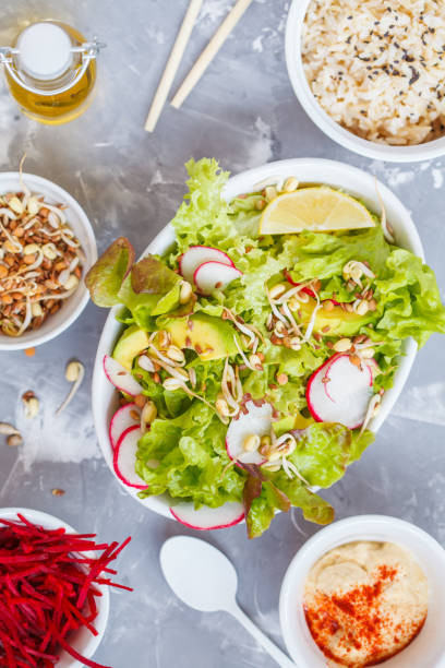 istock Green vegetable salad with rice, hummus and sprouts 883166576