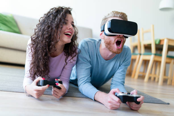 istock Young couple playing games with virtual reality headset 883167742