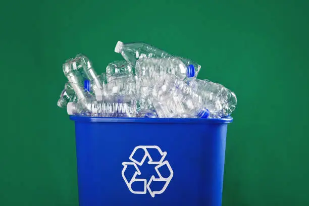 A recycling bin stuffed with plastic water bottles