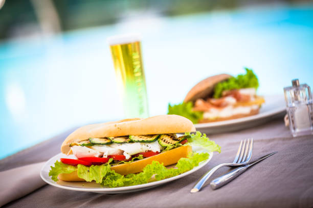 sanduíche e cerveja à beira da piscina - zucchini vegetable food food and drink - fotografias e filmes do acervo