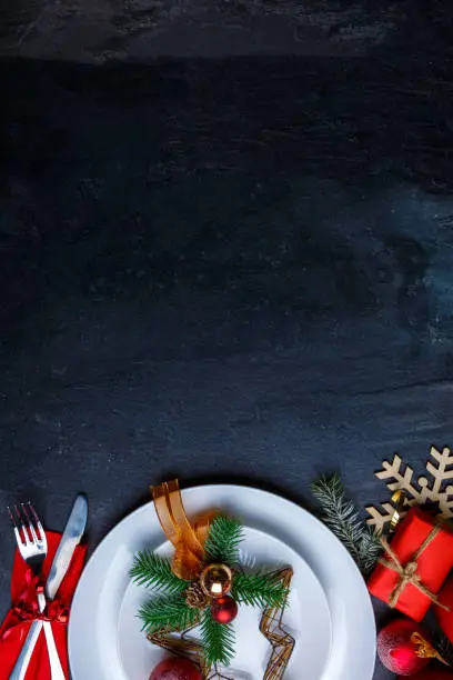 Photo of A background with a place for the inscription is decorated with a plate with Christmas decoration and cutlery.