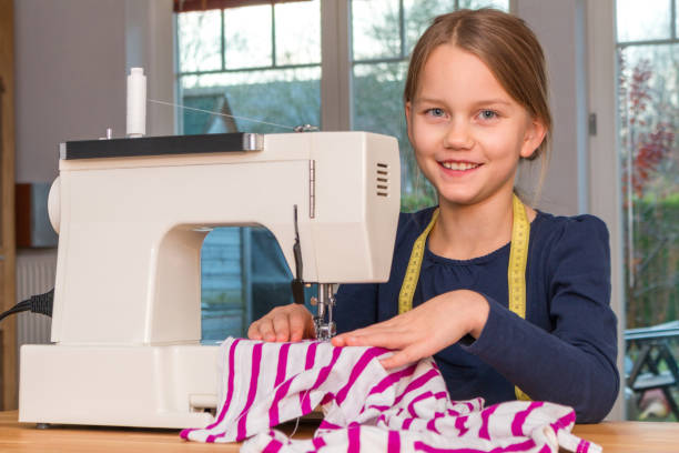 istock Girl sewing with sewing machine 883181874