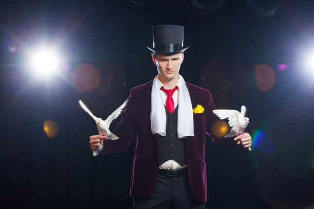 istock The magician with a two flying white Doves. on a black background 883181968