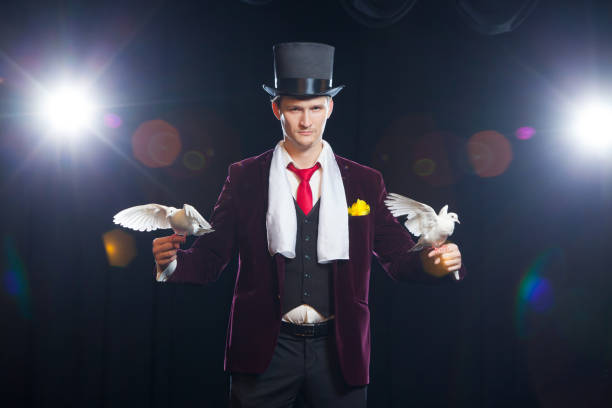 istock The magician with a two flying white Doves. on a black background 883182232