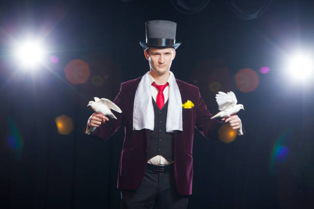 istock The magician with a two flying white Doves. on a black background 883184136