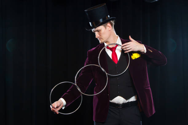 istock magic, performance, circus, show concept - magician in top hat showing trick with linking rings 883184668