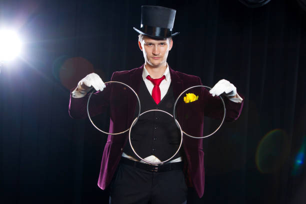 istock magic, performance, circus, show concept - magician in top hat showing trick with linking rings 883184752