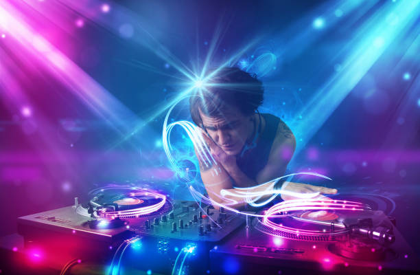 istock Energetic Dj mixing music with powerful light effects 883184890