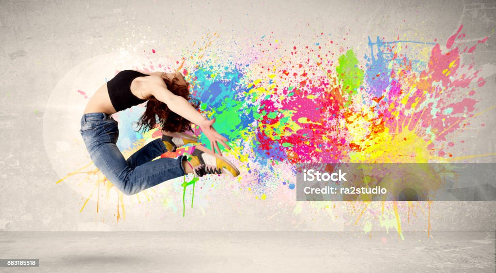 Happy teenager jumping with colorful ink splatter on urban background Happy teenager jumping with colorful ink splatter on urban background concept Paint Stock Photo