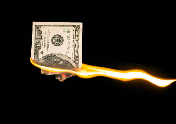 istock a hundred dollars burn in a fire on a black background 883191238