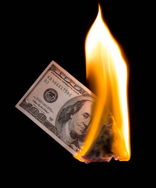 istock a hundred dollars burn in a fire on a black background 883191448
