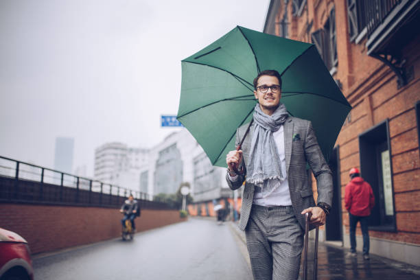 istock Travel man walking with umbrella 883196582