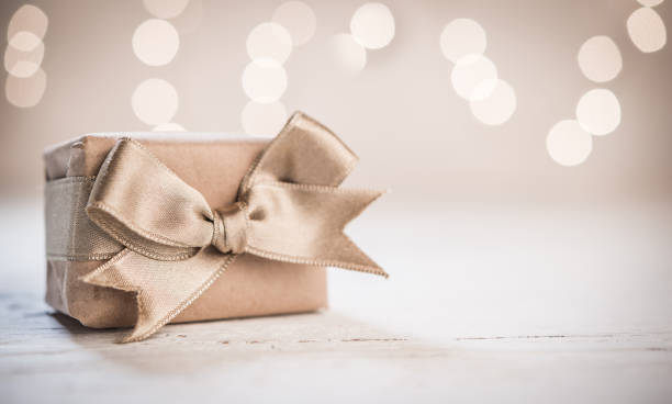 istock Gift box with satin gold ribbon and blurred background 883197180
