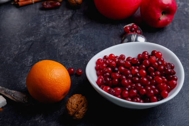 istock On the table is a plate with cranberries and orange. Side view. Indoors. Close up. 883199580