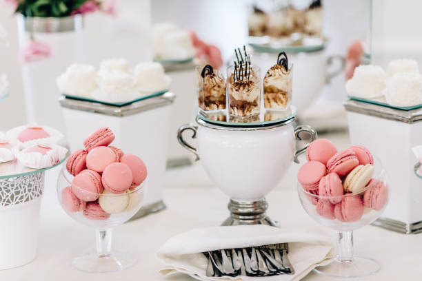 istock Wedding reception dessert table with delicious decorated white cupcakes with frosting 883203318