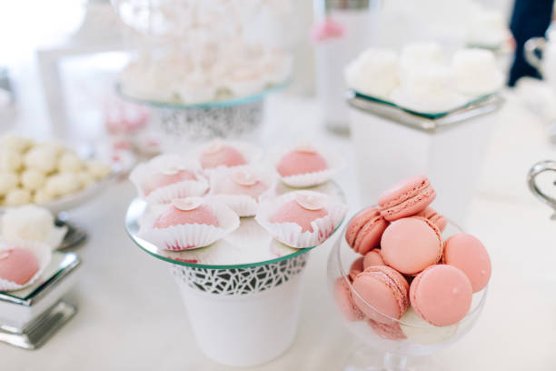 istock Wedding reception dessert table with delicious decorated white cupcakes with frosting 883203688
