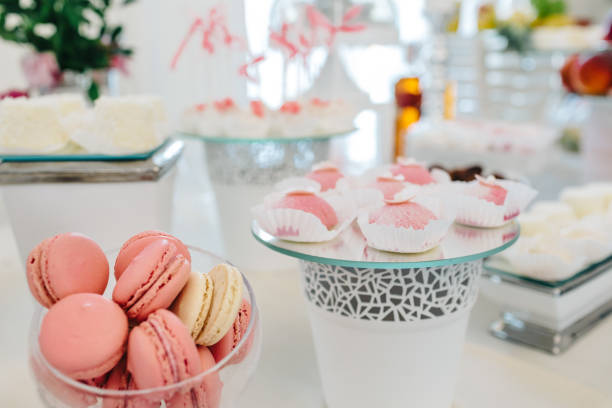 istock Wedding reception dessert table with delicious decorated white cupcakes with frosting 883203812