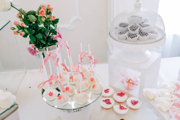 istock Wedding reception dessert table with delicious decorated white cupcakes with frosting 883203946