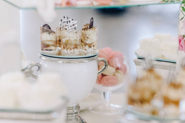 istock Wedding reception dessert table with delicious decorated white cupcakes with frosting 883204224