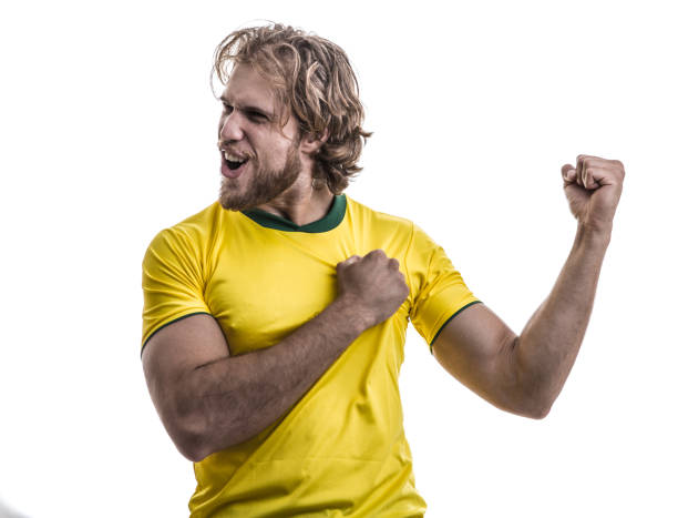 istock Male athlete / fan in yellow uniform celebrating on white background 883205512