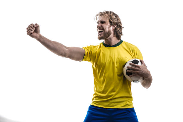 istock Male athlete / fan in yellow uniform celebrating on white background 883205526