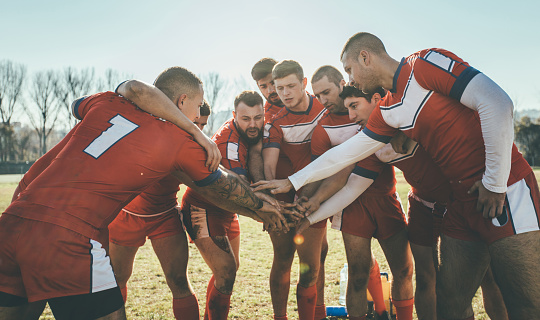 Rugby players huddling during time out. Sports jersey are made specially for shooting purposes.