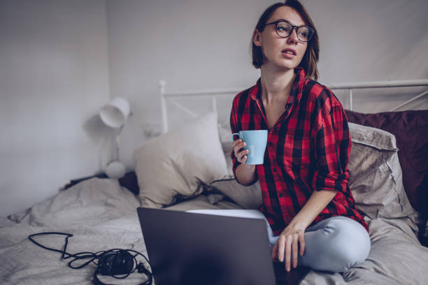 istock Beautiful woman using laptop in bed 883227868