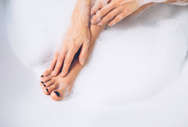 istock Well grooming woman's legs and hands in bath foam close up image 883228772