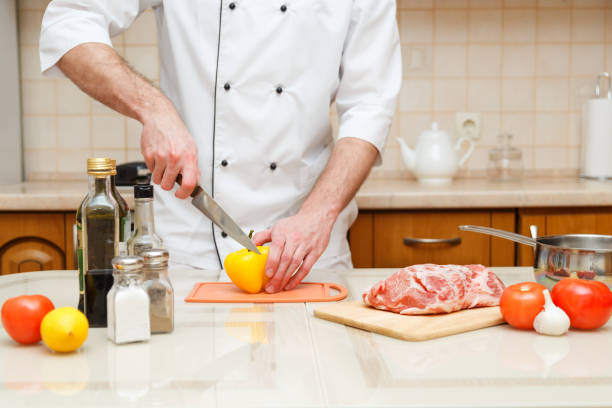 istock closeup on hands cutting yellow pepper on professional kitchen. 883235278
