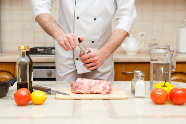istock Man's hand holds bottle with souce. Professional cook prepare the meat 883246892