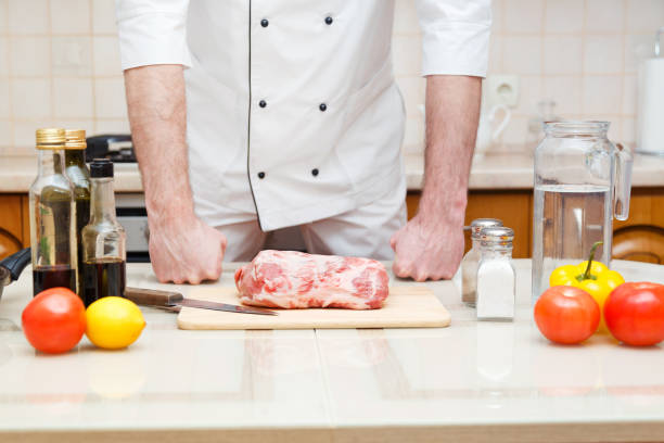 istock Male chef preparing filet pork for cooking at restaurant kitchen. 883261208