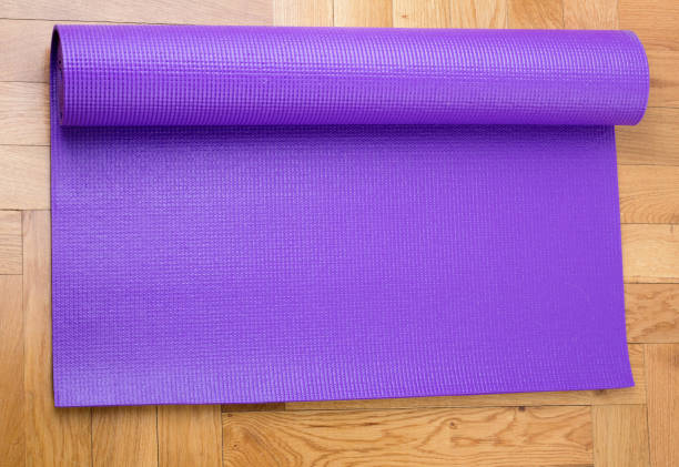 istock Unrolling yoga mat on floor 883271216