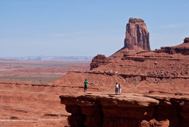 Visitors at John Ford's Point Monument Valley Tribal Park, Arizona, USA - May 15, 2012: Monument Valley, located on the Navajo Nation within Arizona and Utah, has been featured in many western movies since the 1930s. It is perhaps most famous for its use in films by the director John Ford. These visitors are enjoying the view from John Ford's Point, a famous landmark in Monument Valley. jeff goulden monument valley stock pictures, royalty-free photos & images