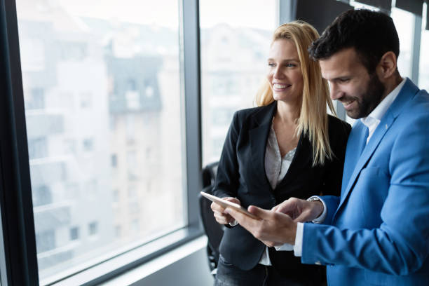 istock Attractive business couple using tablet in modern office 883353034
