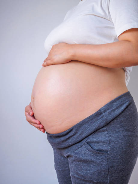 istock pregnant woman touching her belly 883364402