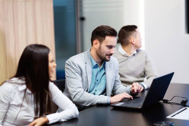 istock Businesspeople working on computer in conference room 883364700