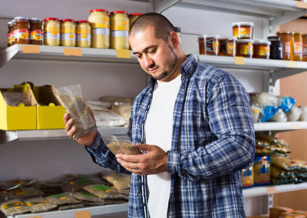 istock Male customer choosing nuts and grain in average food shop 883384116