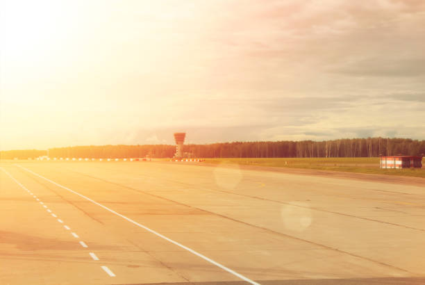 istock Airport runway with a forest at the background on cloudy day, toned background with copy space. 883386484