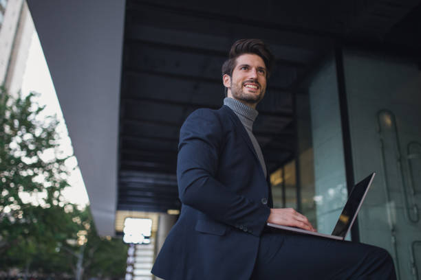 istock Modern businessman with laptop 883510428