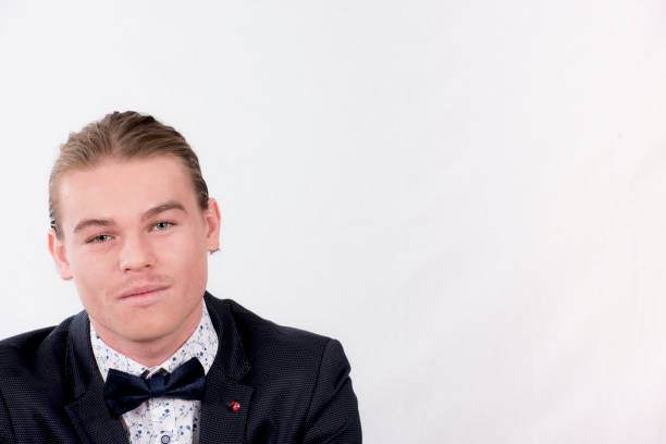 istock Formal Young man with slicked back hair looks at camera. 883510480
