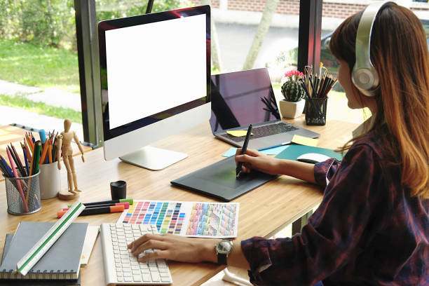 istock Young Asian Graphic designer using graphics tablet to do her work at desk in studio. 883526174